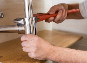 plumber adjusting water pipe
